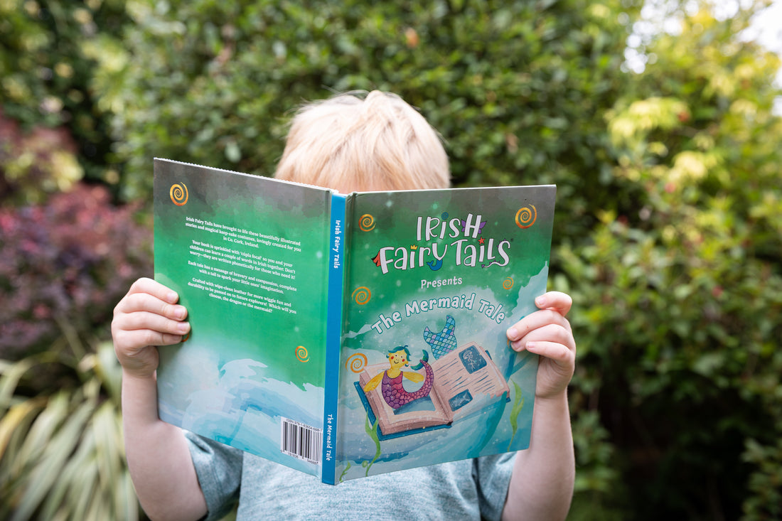 Child reading a book titled The Mermaid Tale by &